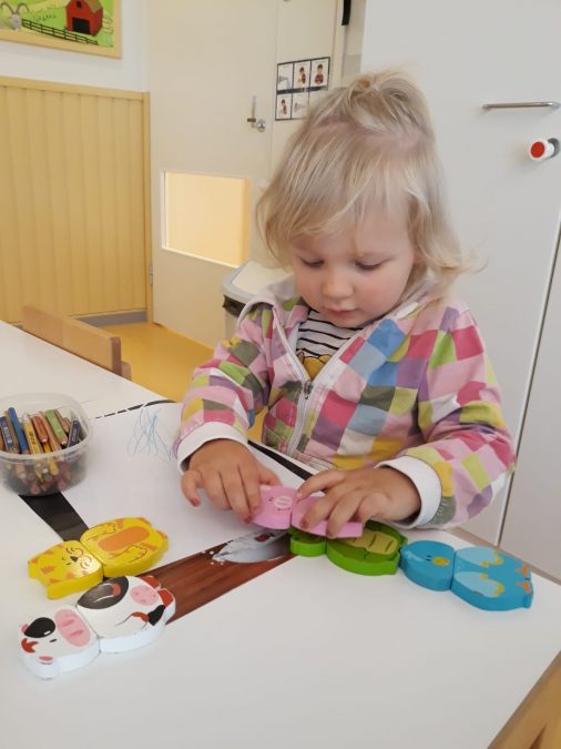 pieni lapsi askartelee pöydän äärellä